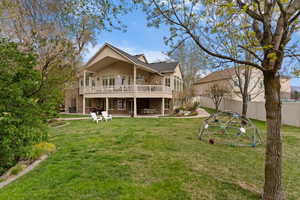 Back of property featuring a patio, brick siding, a balcony, and a playground