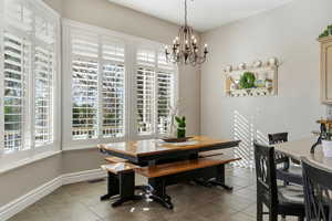 Dining space with light tile patterned floors and hanging lights