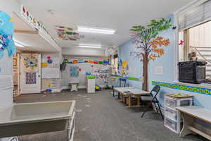 Playroom with dark carpet and baseboards