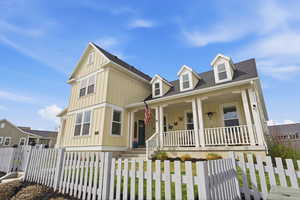 View of front of home with a fenced front yard, board and batten siding, a porch, a shingled roof, and a gate