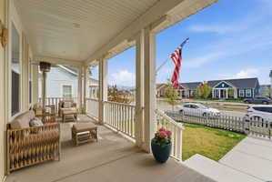 Covered porch featuring a residential view, outdoor lounge area, and a lawn
