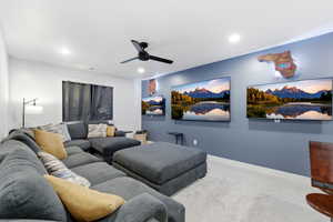 Carpeted cinema room with a ceiling fan and recessed lighting