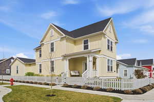 View of front of property featuring board and batten siding, a porch, a fenced front yard, and roof with shingles