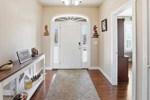 Entryway featuring dark wood-style flooring and hanging lights