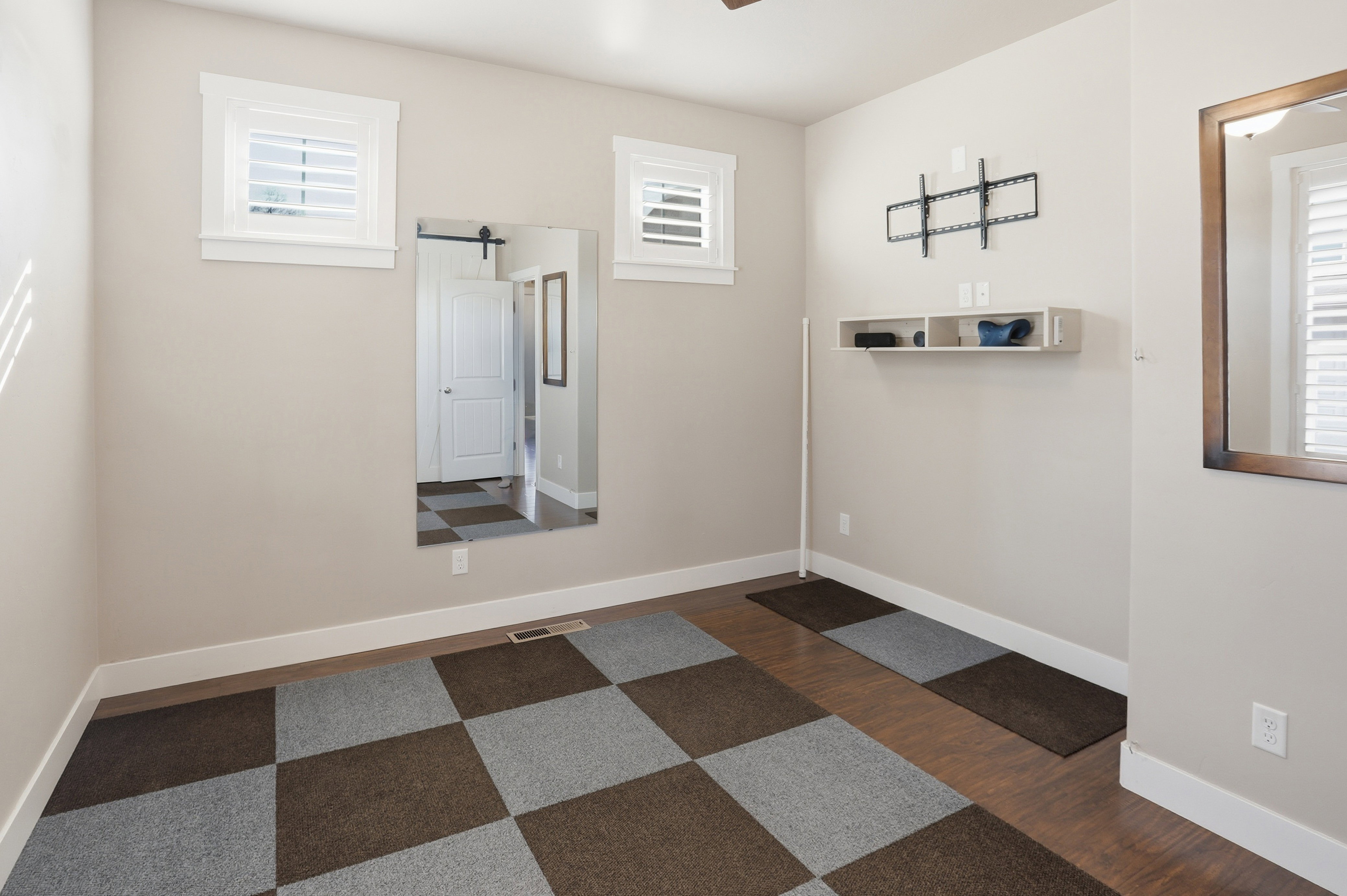 Unfurnished room featuring dark wood finished floors, and healthy amount of natural light