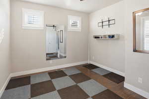 Unfurnished room featuring dark wood finished floors, and healthy amount of natural light