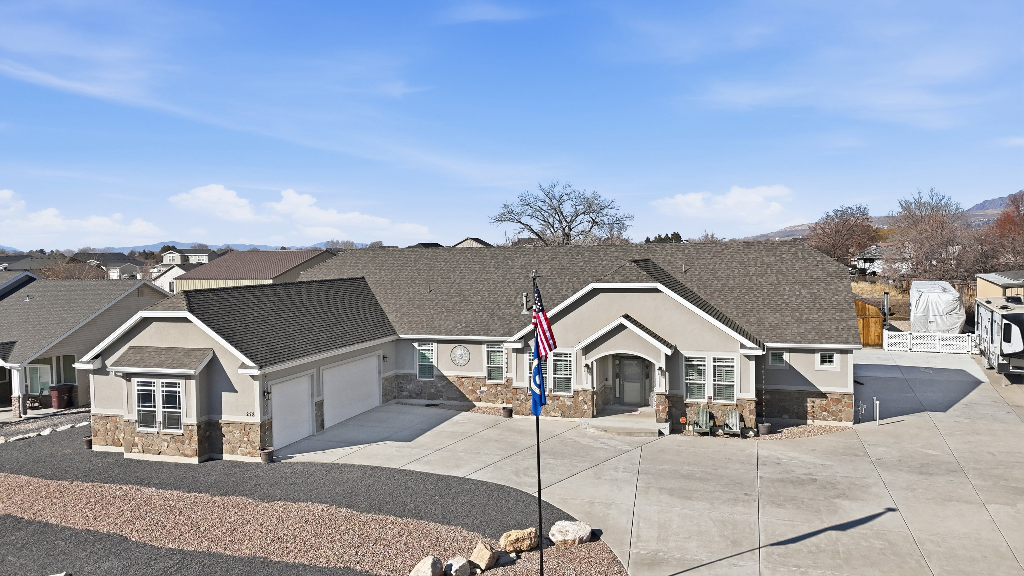 Craftsman-style home with driveway, an attached garage, stone siding, stucco siding, and a residential view
