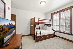 Bedroom with baseboards and light carpet