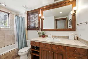 Bathroom with vanity, tiled shower / bath, and recessed lighting