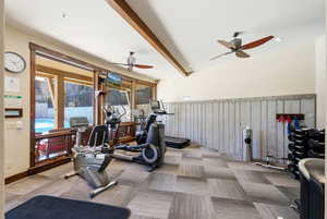Workout room featuring a ceiling fan, beamed ceiling, a wainscoted wall, wood walls, and recessed lighting