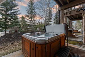 Patio terrace at dusk featuring a patio and a hot tub