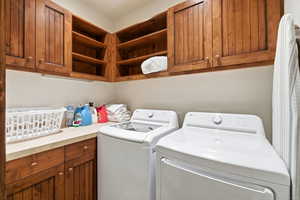 Laundry area featuring cabinet space and separate washer and dryer