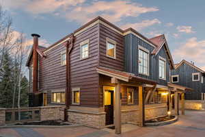View of front of house featuring stone siding and board and batten siding