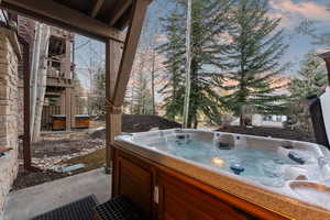 Patio terrace at dusk with a hot tub and a patio area