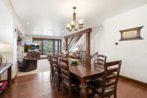 Dining room featuring dark wood-style flooring and suspended lighting