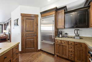 Kitchen with stainless steel built in fridge and dark wood-style flooring