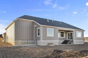 Back of house featuring a shingled roof