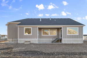 Rear view of property featuring a shingled roof and board and batten siding