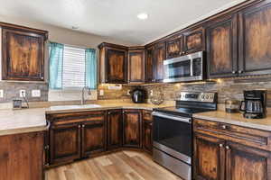 Updated kitchen with stained cabinetry, stainless steel appliances, and an organized reach-in pantry.