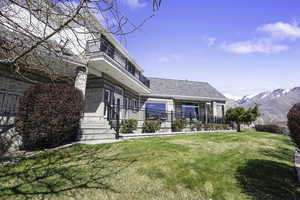 Rear view of house with brick siding, a lawn, and a mountain view