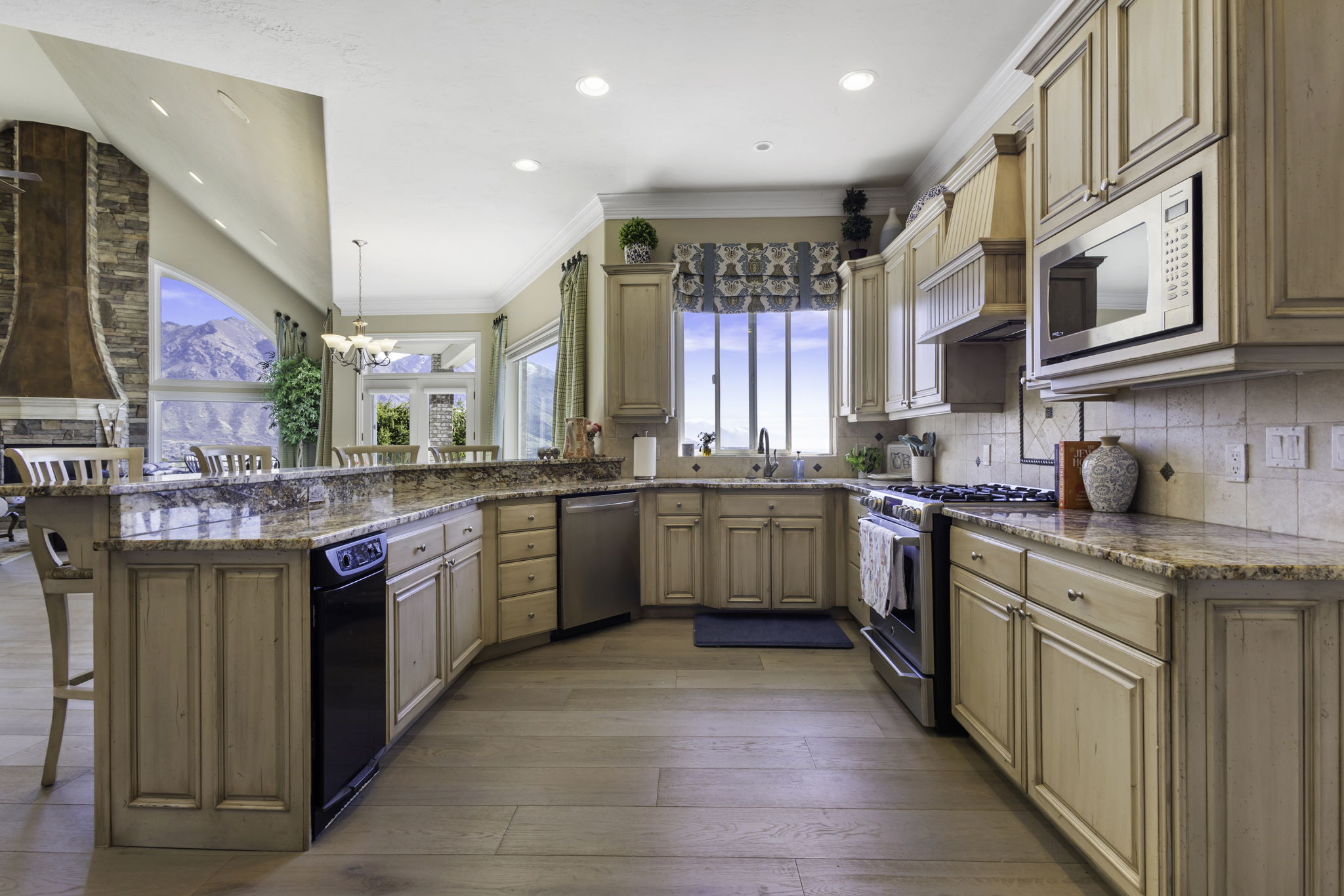 Kitchen featuring a breakfast bar area, stainless steel appliances, light stone countertops, a peninsula, and backsplash