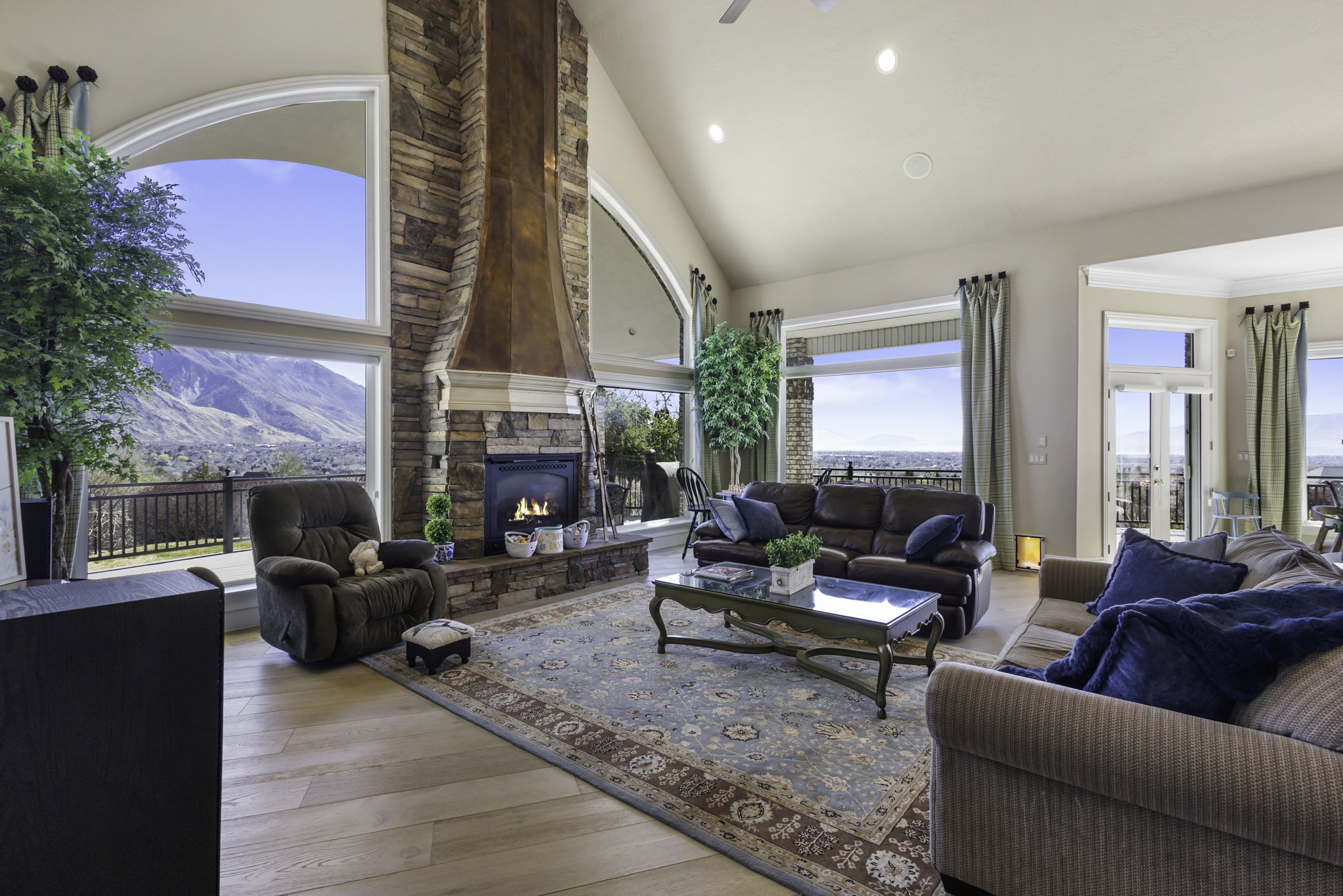 Living area featuring vaulted ceiling, light wood finished floors, recessed lighting, a fireplace, and a ceiling fan