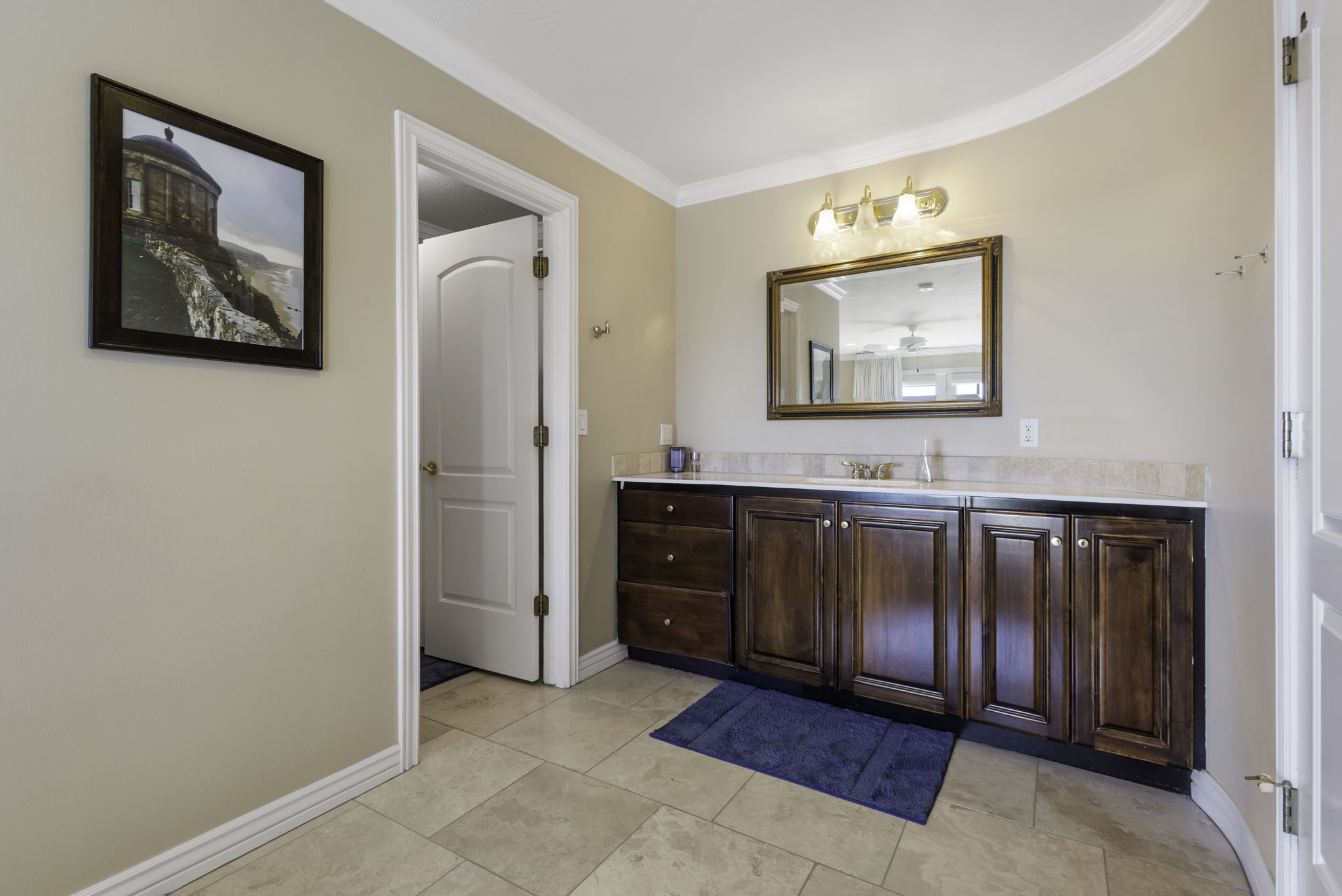 Bathroom with vanity, ornamental molding, and light tile patterned flooring