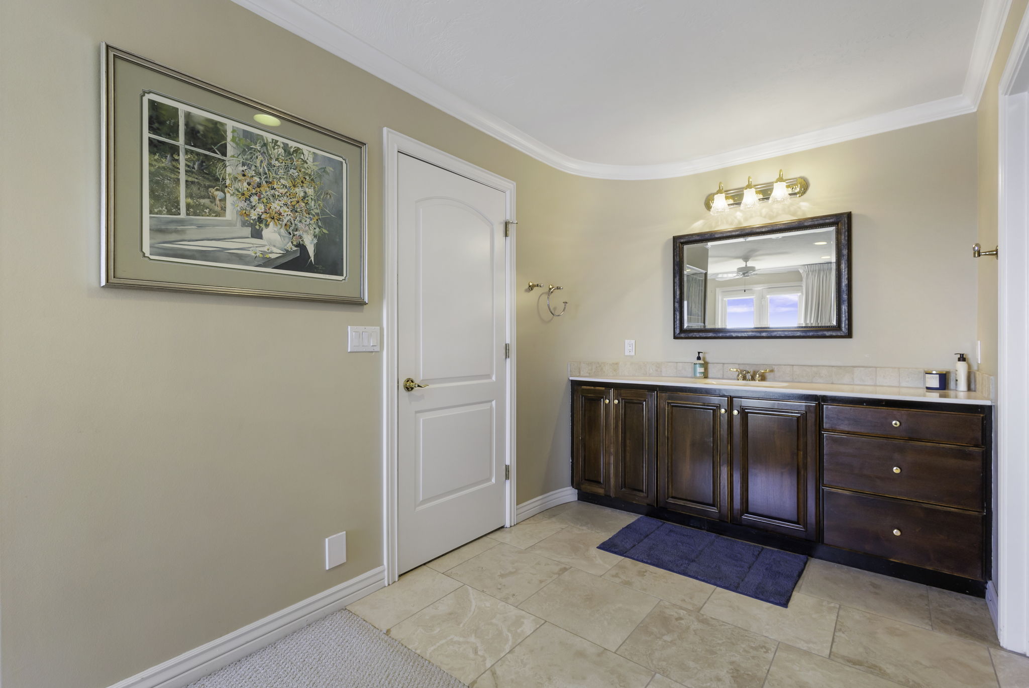 Bathroom with vanity, crown molding, and light tile patterned floors