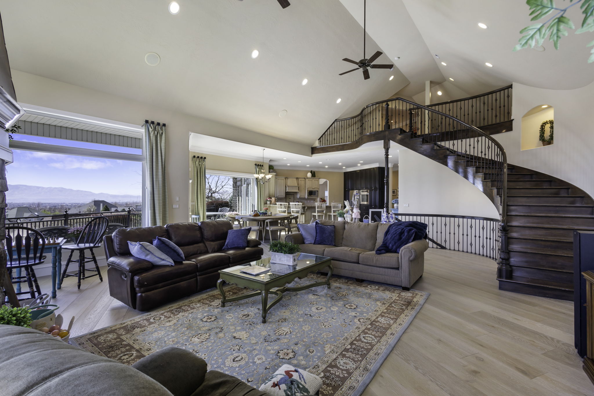 Living room with light wood-style floors, a mountain view, ceiling fan, recessed lighting, and vaulted ceiling