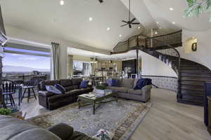 Living room with light wood-style floors, a mountain view, ceiling fan, recessed lighting, and vaulted ceiling