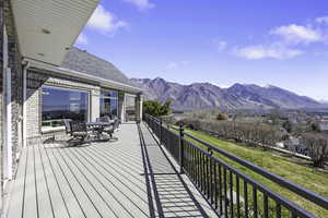 Wooden deck with a mountain view and outdoor dining area