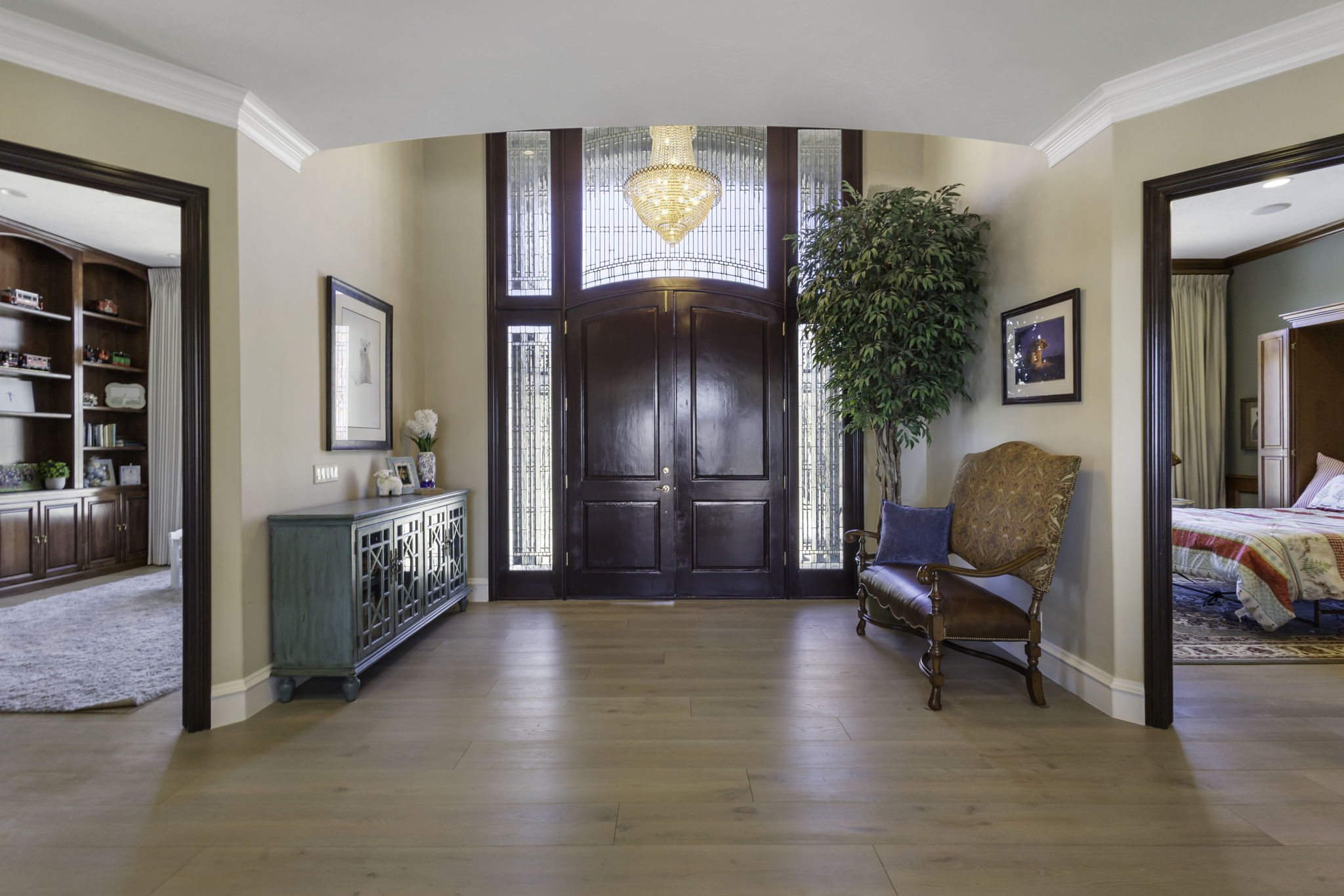 Entryway featuring crown molding, light wood-style floors, and hanging lights