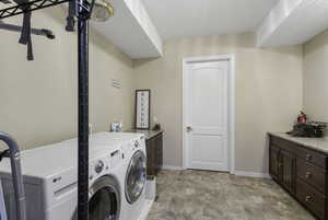 Laundry area featuring stone finish flooring and washer and clothes dryer