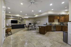 Kitchen with open floor plan, a peninsula, wood finish cabinetry, ceiling fan, and recessed lighting