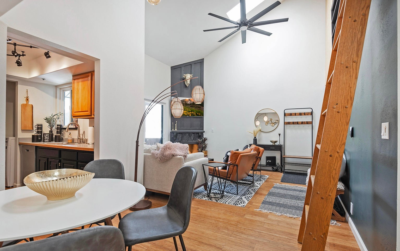 Dining area with light wood-style flooring, ceiling fan, and lofted ceiling