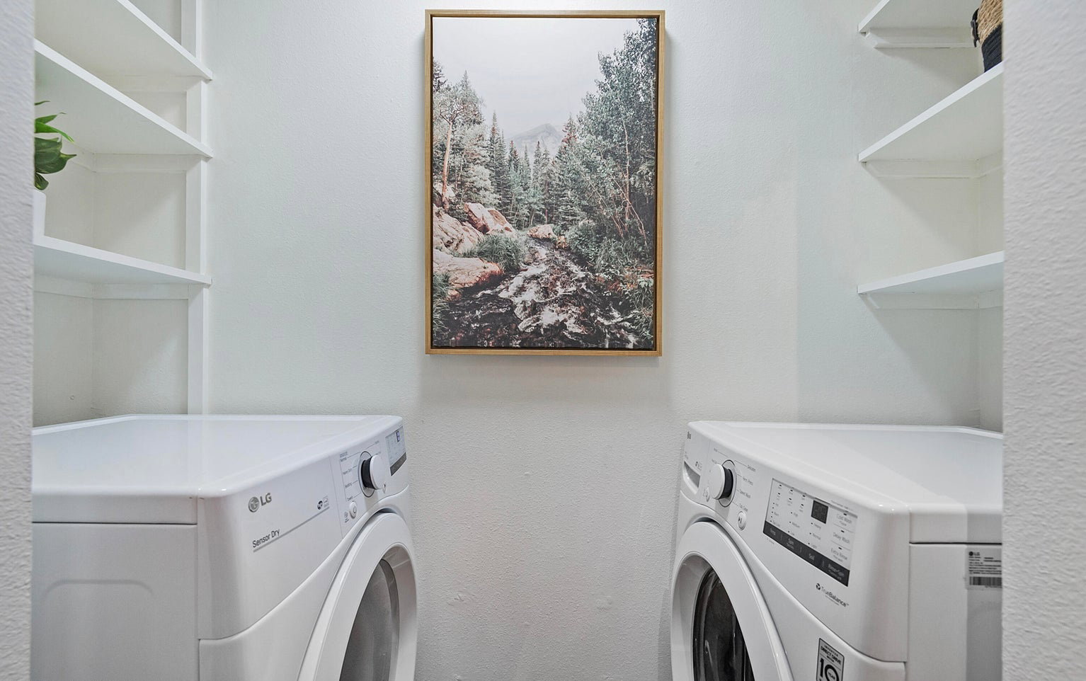 Laundry area with washing machine and dryer and a textured wall