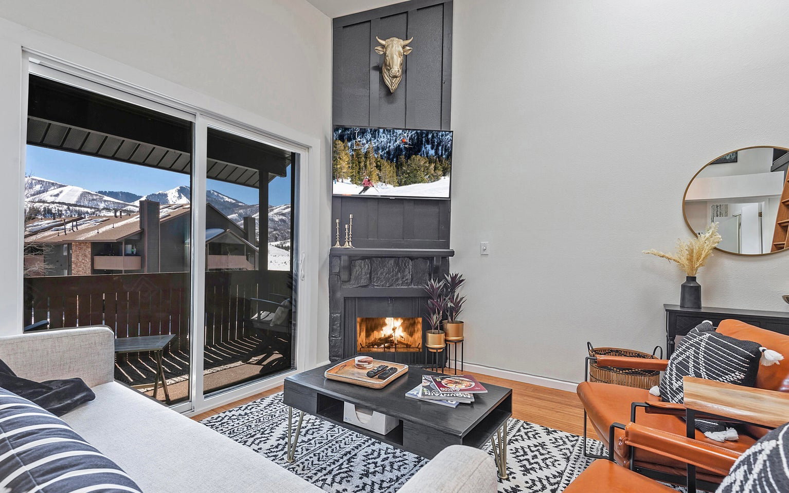 Living room with a lit fireplace and light wood-style floors