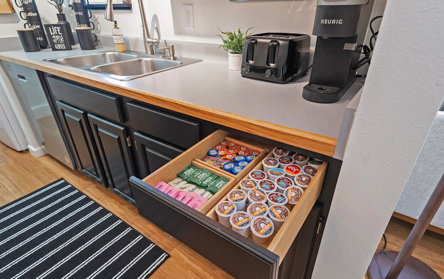 Kitchen featuring light countertops, dishwasher, and dark cabinetry