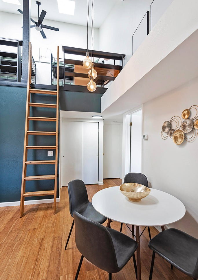 Dining space featuring light wood-style flooring, a ceiling fan, and a high ceiling