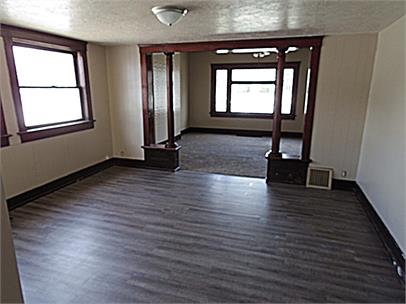 Empty room featuring a textured ceiling and dark wood-style flooring