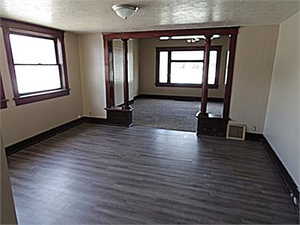 Empty room featuring a textured ceiling and dark wood-style flooring