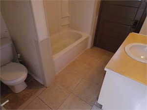 Full bath with vanity and light tile patterned floors