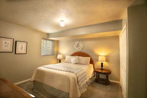 Bedroom featuring a textured ceiling, a closet, and carpet flooring