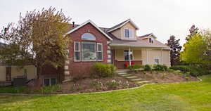 View of front of home featuring a porch, a front yard, brick siding, and stucco siding