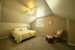 Bedroom featuring a textured ceiling, carpet, and ceiling fan