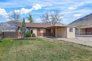 Rear view of house with a mountain view, a patio area, and brick siding