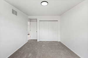 Unfurnished bedroom with carpet flooring and a closet