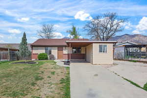 Ranch-style house featuring concrete driveway, an attached carport, a mountain view, and brick siding