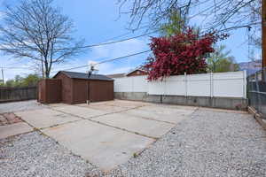 Fenced backyard with a shed and a patio