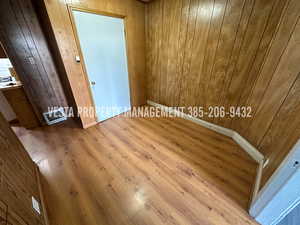 Unfurnished room featuring wood finished floors and wood walls